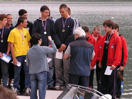 A na záver prvej časti fotoreportáže z MSR KT vo Zvolene jedna tlačenica na stupňoch víťazov v podaní ml.dorcov v kategórii C4 1000m. Na moje prekvapenie sa aj Marián Ostrčil živo zaujímal o priebeh ich pretekov najmä na C1, keď pozorne sledoval ich dojazd. Vysvetľoval mi to aj tým, že ho zaujíma, či sa objavia nejakí právaci a aj ako jazdia jeho nasledovníci z domovského oddielu Vinohrady Bratislava (Marsal s Poliakom). Zostáva len dúfať, že niektorí z týchto mladíkov na stupni víťazov budú pokračovať v jeho šľapajách...resp. v olympijských záberoch.