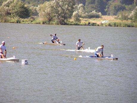 A o tom, že sa Mário pripravil a rozjazdil dobre, svedčí aj tento pohľad na finiš kanoistickej tisícky. Opticky sa zdá, že práve Mário je vpredu aj pred bratom Mariánom (číslo 5), ale naša kanoistická jednotka už spokojne vydychuje v cieli. Ostatní (s číslom 2 Rado Rus a s číslom 3 Daniel Biksadský) ešte tvrdo makajú, aby....